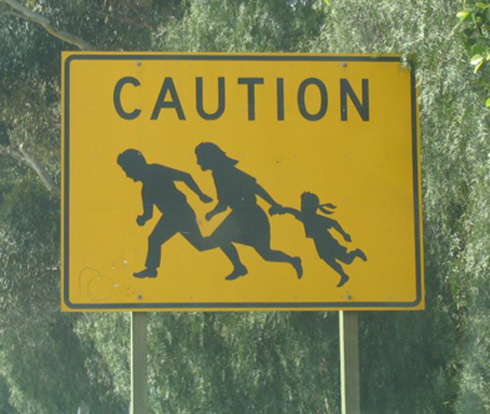 Immigrant Crossing Road Sign [Newspaper Article and Photograph]